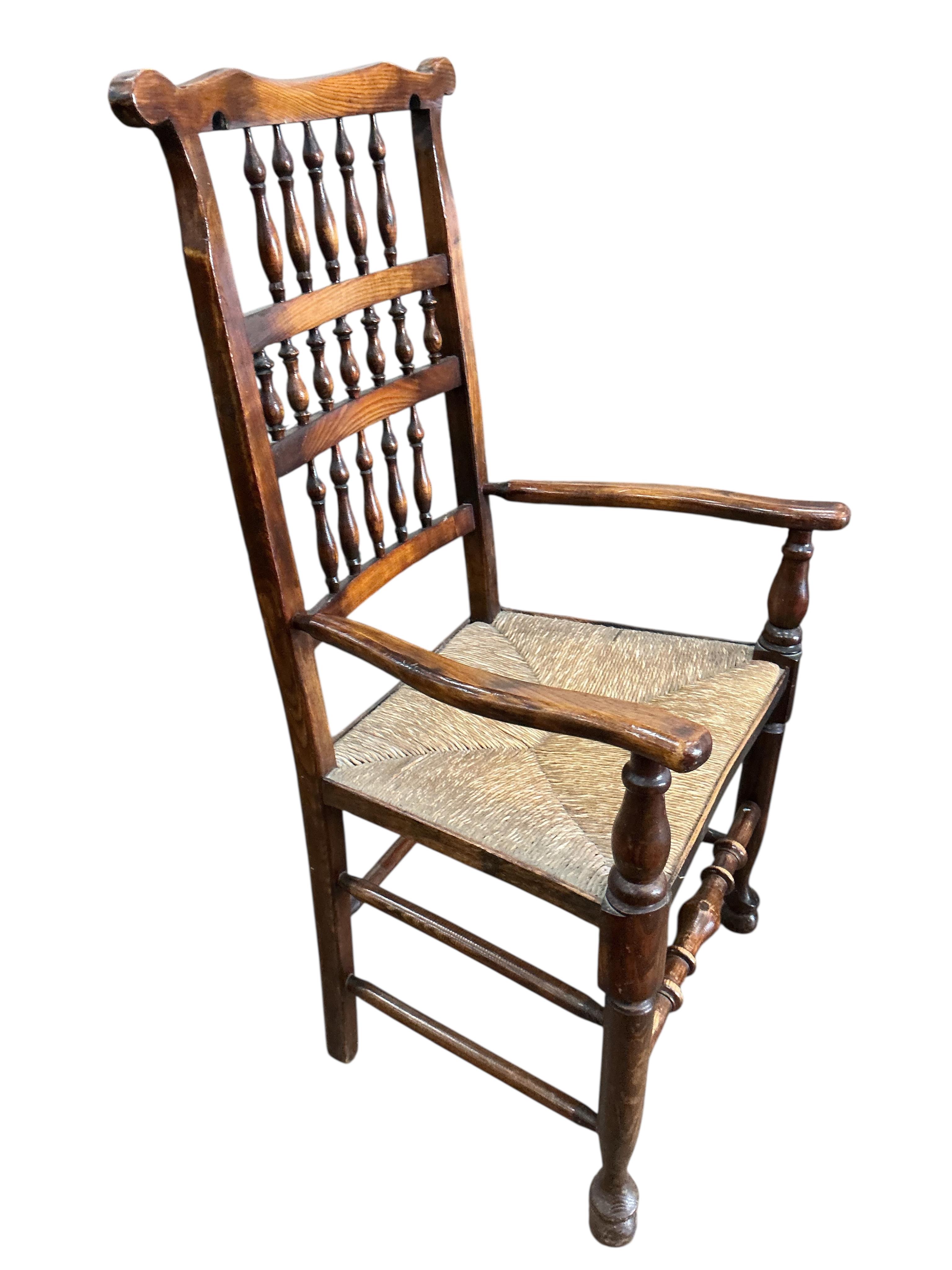 A harlequin set of eight (six plus two) Derbyshire style elm and beech rush seat spindle back dining chairs, two with arms